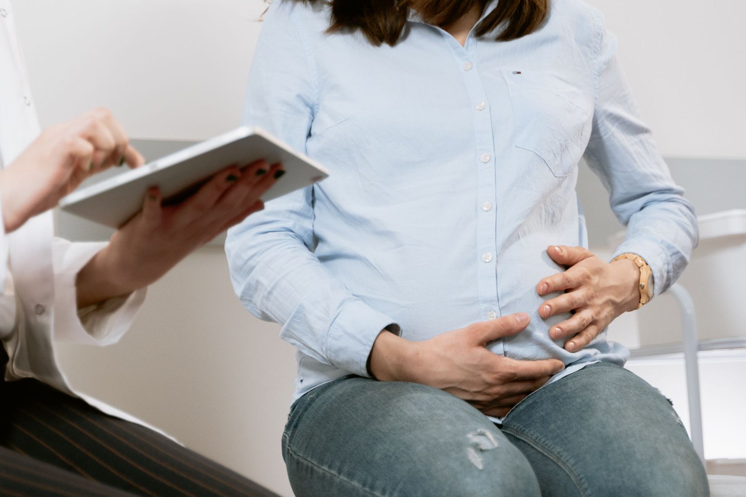 Ärztin bespricht mit einer Patientin Unterlagen auf einem Tablet