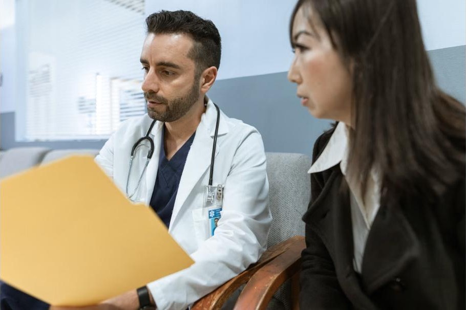 Hausarzt und Ärztin besprechen Patientenunterlagen in der Praxis