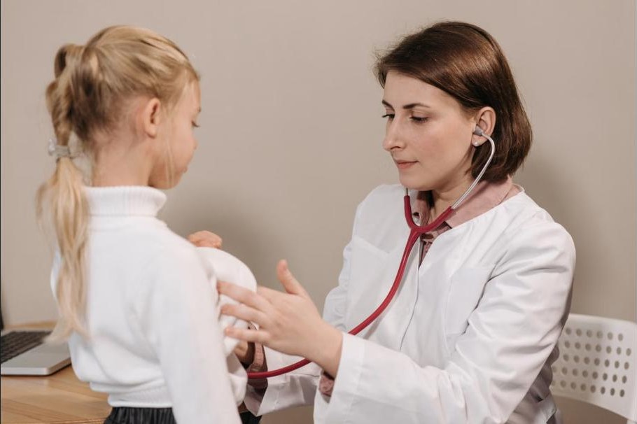 Internistin untersucht eine junge Patientin mit dem Stethoskop