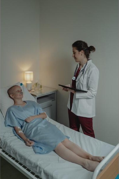Onkologe bei der Visite am Krankenbett