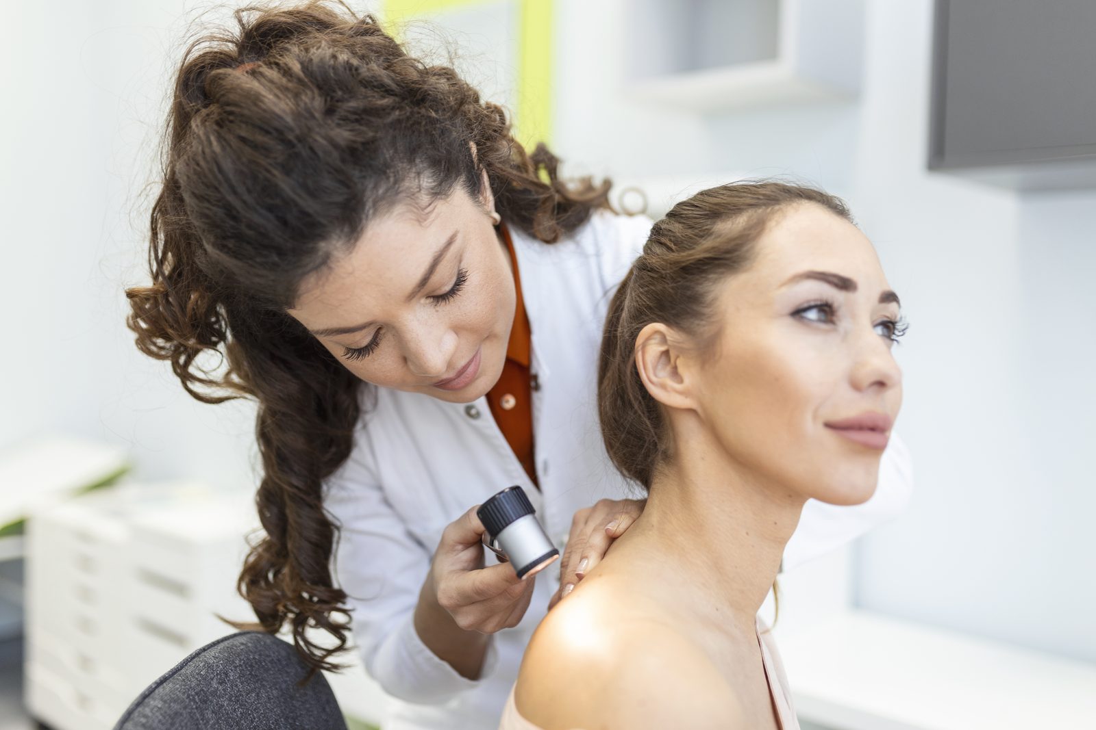 Hautärztin untersucht die Haut einer Patientin