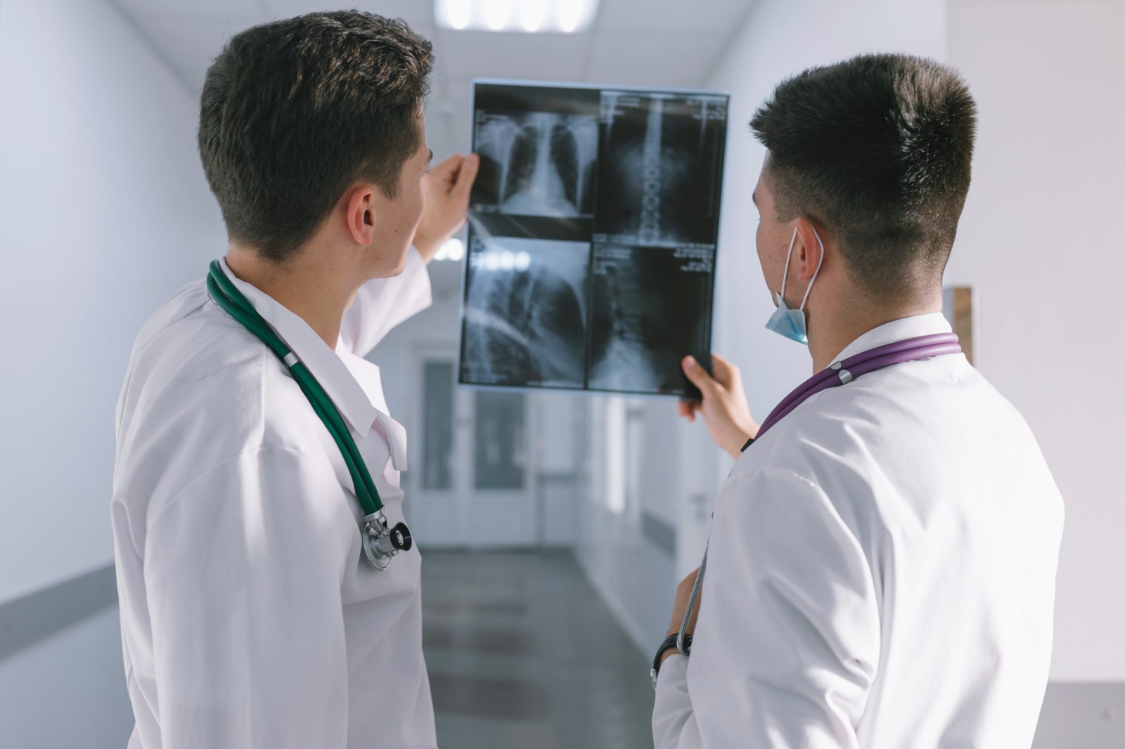 Zwei Ärzte besprechen einen Röntgenbefund im Klinikflur