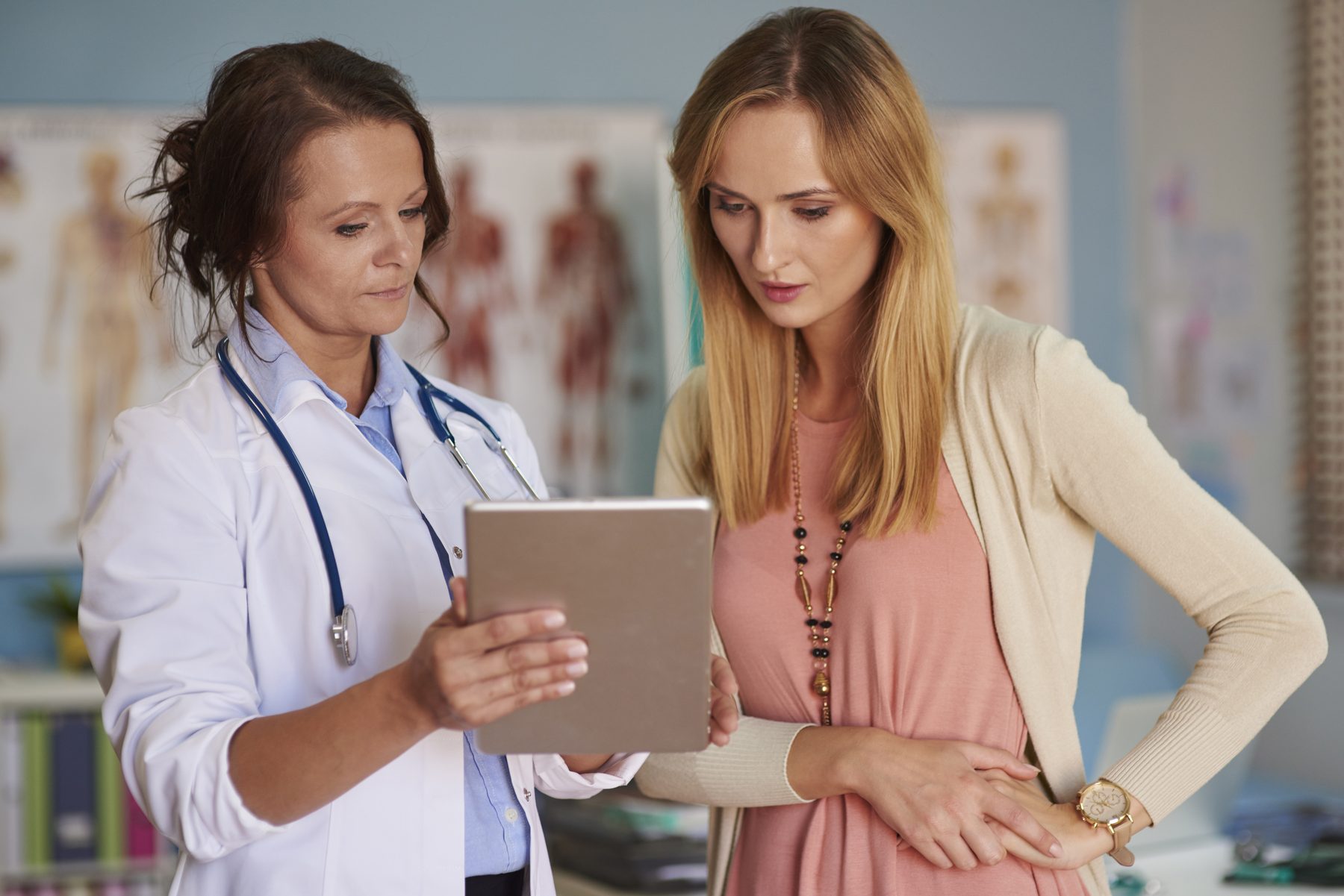 Gynäkologin bespricht mit einer Patientin Untersuchungsergebnisse am Tablet